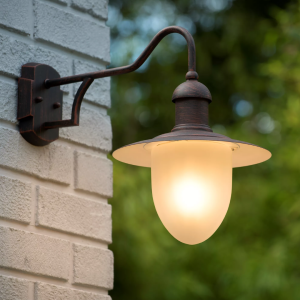 Buitenwandlamp in roestbruine afwerking met matglazen kap aan witte muur