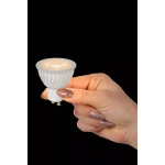 Witte GU10 ledspot in hand met warm licht uitstralend