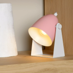 Roze metalen tafellamp met witte voet op houten kast verlicht hoek zacht
