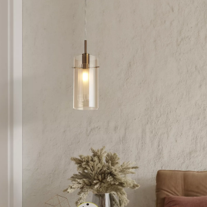 Bronzen hanglamp met champagnekleurig glas boven zithoek met beige muur