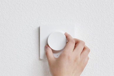 Witte LED dimmer met ronde draaiknop aan muurbediening