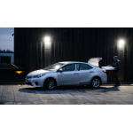 LED schijnwerper koelwit licht aan gevel bij geparkeerde auto