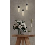 Hangende buislampen met warm licht boven houten tafel met bloemenvaas