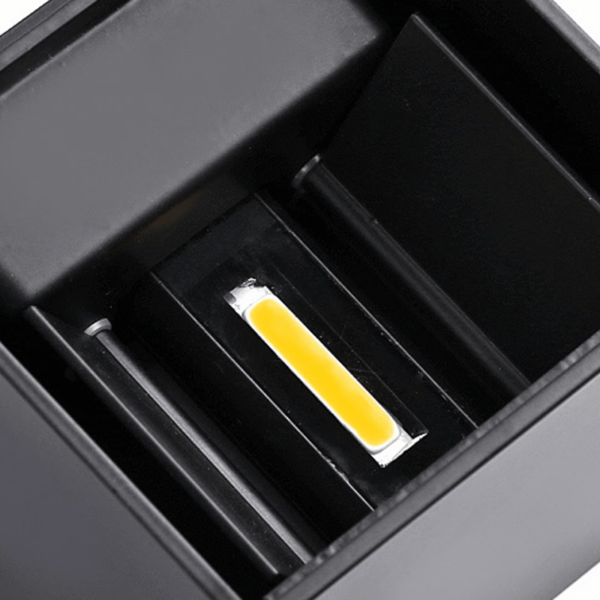 Zwarte wandlamp cube met zichtbaar geel led element binnenin