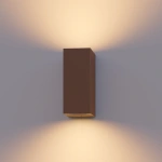 Roestbruine buitenwandlamp met up en downlight lichteffect tegen muur