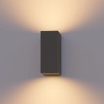 Grijze buitenwandlamp met up en downlight verlichting tegen muur