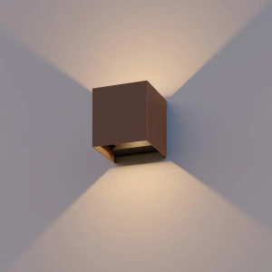 Roestkleurige kubus wandlamp met warmwit up en downlight tegen muur