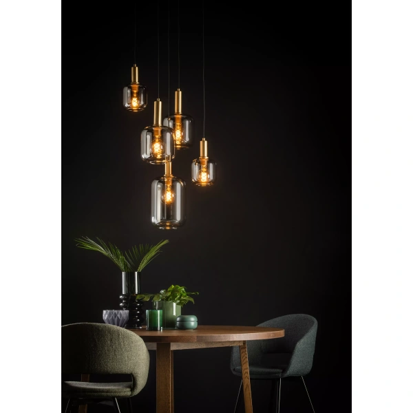 Hanglamp met vijf glazen kelken boven een houten eettafel met planten