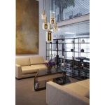 Hanglamp met vijf glazen fittingen boven moderne zithoek met beige banken
