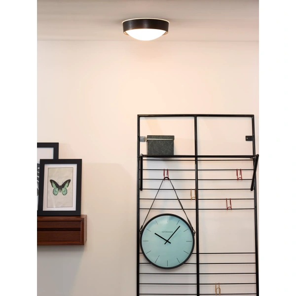 Zwarte plafondlamp met ronde witte kap in moderne woonkamer setting