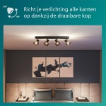 Zwarte plafondspot met vier gerookte glazen lampkoppen boven zithoek