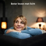 Vrouw ontspannen op bank met warme lamp en haardvuur op achtergrond