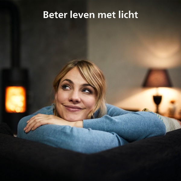 Vrouw ontspannen op bank met warme lamp en haardvuur op achtergrond