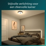 Ronde zwarte plafondlamp verlicht moderne slaapkamer met neutrale tinten
