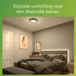 Ronde plafondlamp verlicht slaapkamer met bed en wanddecoratie