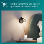 Zwarte wandspot met gerookt glas boven nachtkastje naast bed