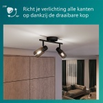 Zwarte plafondspot met twee draaibare lampen van gerookt glas in woonkamer