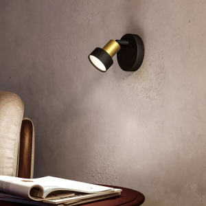 Zwarte en gouden plafondspot met één lichtpunt aan muur boven bijzettafel
