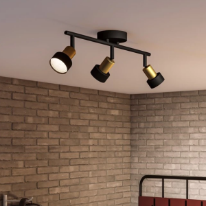 Zwarte en gouden plafondspot met drie richtbare lampkoppen in moderne woonkamer