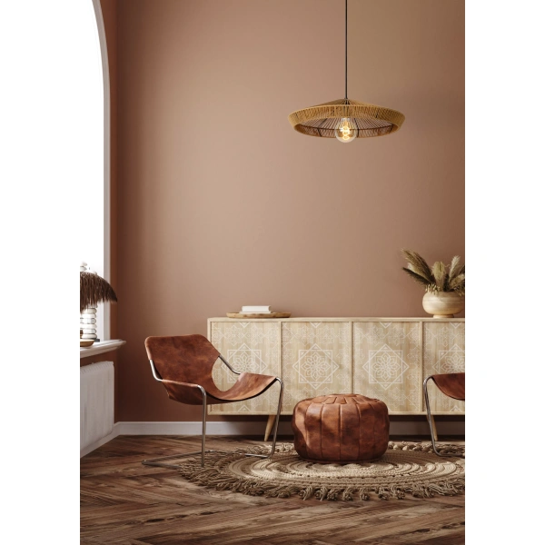 Rotan hanglamp met zichtbare gloeilamp boven zithoek in woonkamer.
