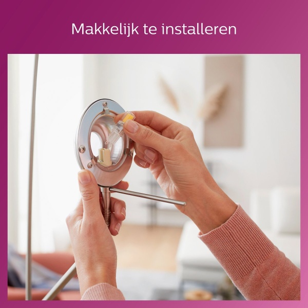 Handen plaatsen een G9 buislamp in metalen lampfitting binnen woonkamer