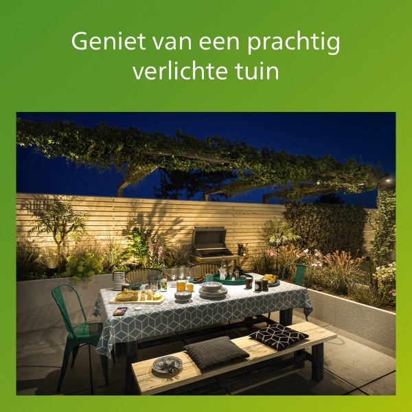Tuinset met gedekte tafel onder warme buitenverlichting in avondtuin