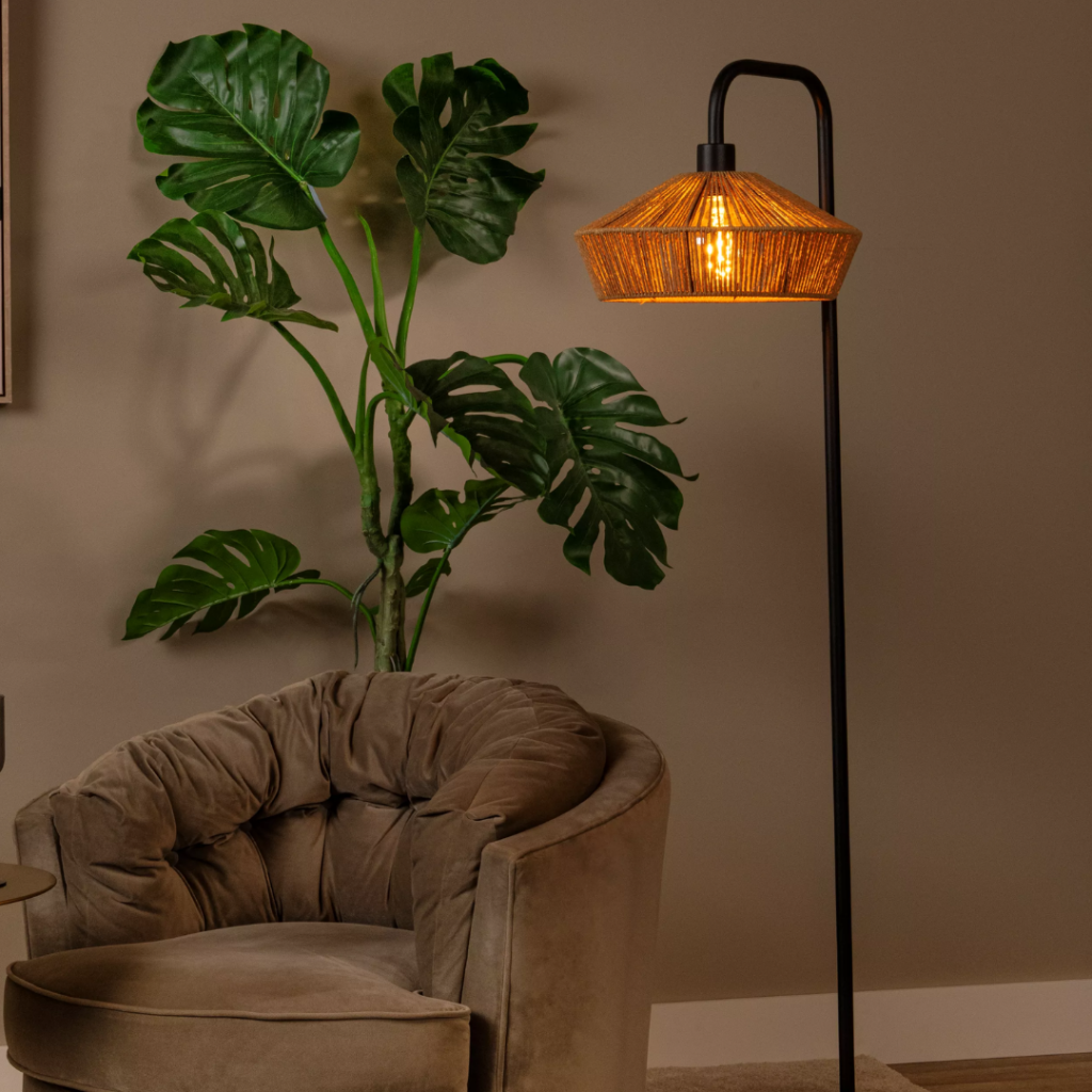 Vloerlamp van rotan in naturel tint met warm licht in zithoek