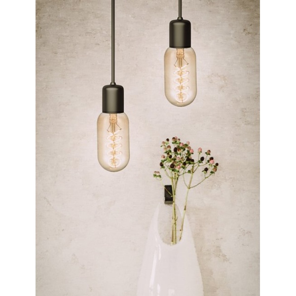 Hangende buislampen met goudkleurig filament boven vaas met takjes.