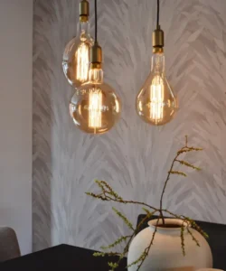 Hangende retro gloeilampen met warm licht boven eettafel en vaas