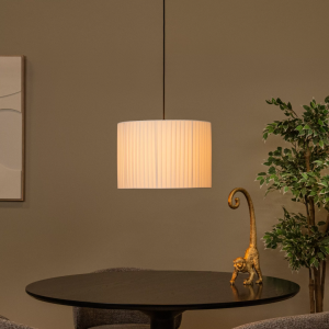 Ronde witte hanglamp met geplooide kap boven eettafel in moderne woonkamer
