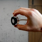 Mini inbouwspot zwart met ronde rand vastgehouden tussen vingers