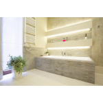 Ingebouwde LED stripverlichting boven modern ligbad met stenen afwerking