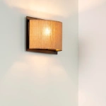 Bamboe wandlamp in naturel tint met warm licht tegen lichte muur