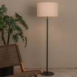 Beige vloerlamp met stoffen kap en zwarte metalen voet in woonkamerinterieur