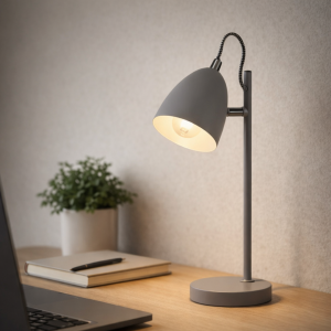 Grijze moderne bureaulamp met matte afwerking op houten bureau naast laptop