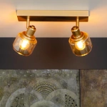 Gouden messing plafondspot met twee verstelbare lichtpunten boven wanddecoratie