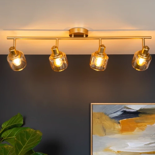 Gouden messing plafondspot met vier verstelbare lichtpunten boven moderne woonkamer