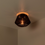 Zwarte Scandinavische plafondlamp met geweven kap en warm licht in interieur