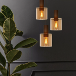 Hanglamp met drie koperen fittingen en amberkleurig glas in moderne woonkamer