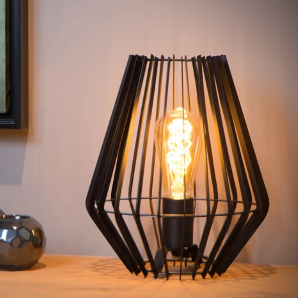 Zwarte metalen tafellamp met open frame en warme gloeilamp op houten tafel