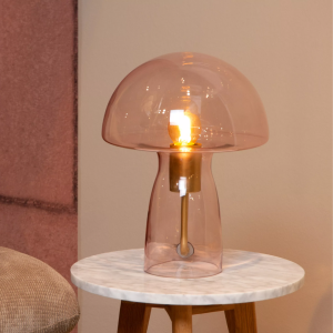 Roze glazen paddenstoel tafellamp met messing fitting op marmeren bijzettafel