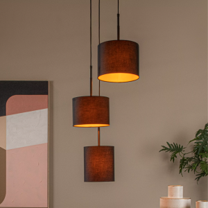 Zwarte drievoudige hanglamp met cilindrische kappen in warme woonkameromgeving