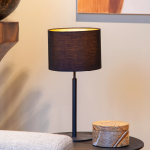 Zwarte Scandinavische tafellamp met stoffen kap op ronde tafel in woonkamer