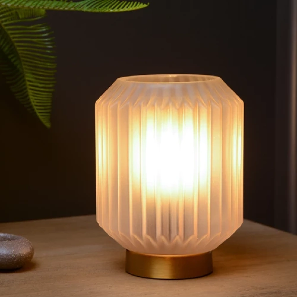 Grijze tafellamp van mat glas met warme gloed op houten tafel