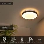 Zwarte ronde plafonniere met warm wit licht aan plafond in moderne kamer