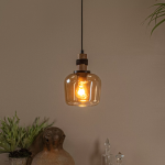 Amberkleurige glazen hanglamp met warme gloed boven houten decoratie in interieur