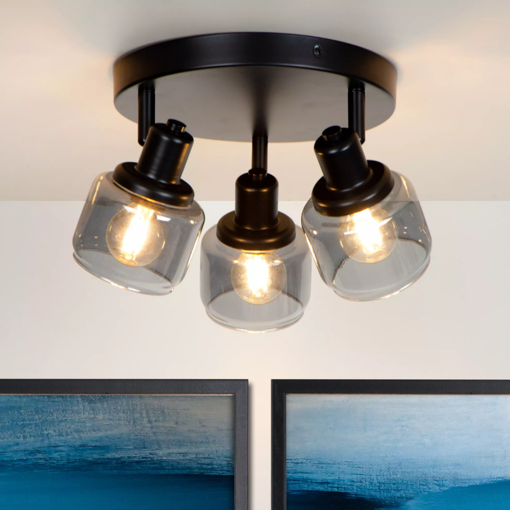 Zwarte plafondspot met drie verstelbare glazen lampenkappen boven wanddecoratie