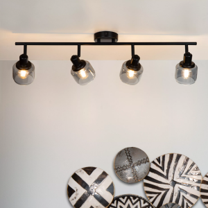 Zwarte plafondspot met vier verstelbare lampen en glazen kappen in moderne woonkamer