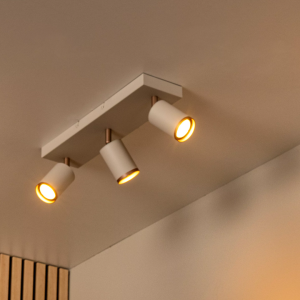 Witte plafondspot met drie verstelbare cilinderlampen en warm licht in modern interieur
