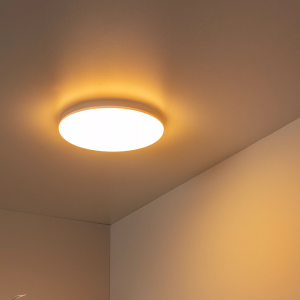 Ronde opaalwitte plafonnière met warm licht in moderne interieurhoek